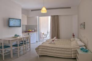 Aloe Apartments في مدينة ريثيمنو: غرفة نوم بسرير وطاولة ومطبخ
