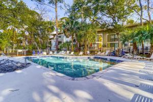 a swimming pool with chairs and trees and a building at Seascape Villas, Unit 3239 in Hilton Head Island