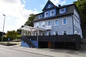 a large blue house with a balcony on a street at Hotel Kornblume in Haundorf