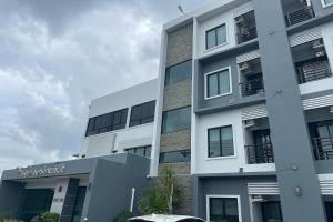 um prédio de apartamentos com um carro estacionado em frente em De Piraya residence em Ban Bo Sai Klang