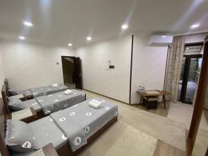 um quarto com três camas e uma mesa em Town House em Samarkand