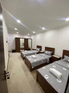 um quarto com três camas num quarto em Town House em Samarkand