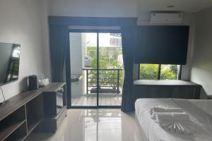 1 dormitorio con 1 cama y puerta a un balcón en De Piraya residence, en Ban Bo Sai Klang