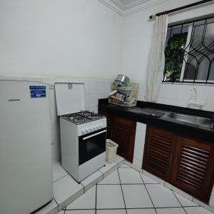 a small kitchen with a stove and a sink at The Majestic Royal Palms, Mtwapa in Shimo la Tewa