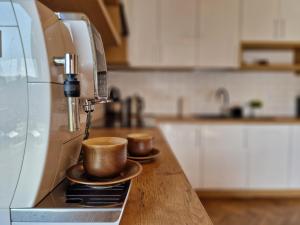 two cups sitting on a counter next to a coffee machine at Nad Zalew in Sromowce Wyżne