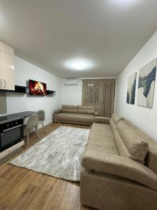 een woonkamer met een grote bank en een tv bij Apartmani IMPERIAL 2 in Novi Pazar