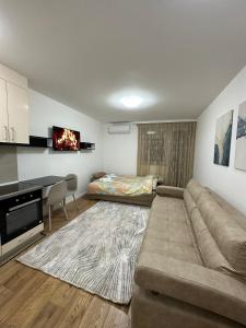 een woonkamer met een bank, een tafel en een bed bij Apartmani IMPERIAL 2 in Novi Pazar