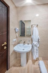 bagno con lavandino bianco e specchio di Dzvel Ubanshi a Gori