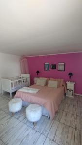 1 dormitorio con 1 cama grande y pared de color rosa en La Pascuala en Balneario Claromecó