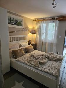 1 dormitorio con 1 cama grande y ventana en Beach House en Międzyzdroje