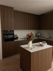 a kitchen with a counter with a vase of flowers on it at Spectacular apartment, all new with fantastic view in Reykjavík
