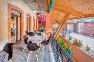 jadalnia ze stołem i krzesłami na balkonie w obiekcie Dzvel Ubanshi w mieście Gori