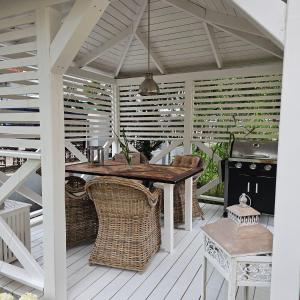 an outdoor kitchen with a wooden table and wicker chairs at Beach House Old in Międzyzdroje