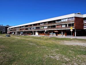 a large building with a grass field in front of it at Appartement Chamrousse, 2 pièces, 6 personnes - FR-1-549-11 in Chamrousse