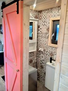 a pink door in a tiny house bathroom at Maringotka_naluke in Detvianska Huta