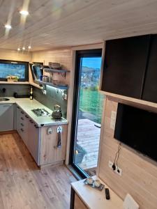 a kitchen in a tiny house with a large window at Maringotka_naluke in Detvianska Huta