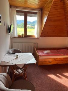 a room with a bed and a table and a window at Penzion Na Vyhlídce in Frýdlant nad Ostravicí