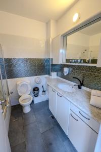 a bathroom with a toilet and a sink and a mirror at Geula 1 in Tel Aviv +51 photos