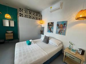 a bedroom with a bed and a table and posters at El Barrio Hostal in Cartagena de Indias
