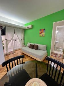 un soggiorno con letto e pareti verdi di Bulnes Apartment a Buenos Aires
