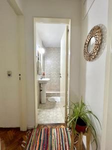 y baño con aseo, lavabo y espejo. en Bulnes Apartment en Buenos Aires