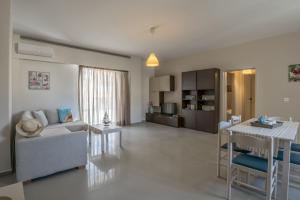 Aloe Apartments في مدينة ريثيمنو: غرفة معيشة مع أريكة وطاولة