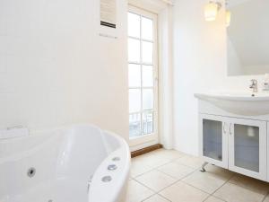 a white bathroom with a tub and a sink at 8 person holiday home in Gjern-By Traum in Gjern +14 photos