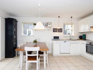 a kitchen with a wooden table and white cabinets at Holiday Home Troldbjergvej IV in Gjern