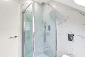 a shower with a glass door in a bathroom at Massive west London 7 bed modern in London