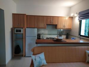 una cucina con mobili in legno e un frigorifero bianco di Ca n'Antonia Mestre a Playa Migjorn