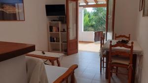 un soggiorno con tavolo, sedie e televisione di Ca n'Antonia Mestre a Playa Migjorn