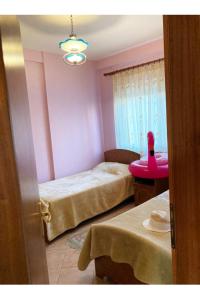 um quarto com 2 camas e uma mesa rosa em Armand’s apartament em Golem