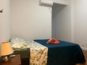 a bed with a blue blanket and a stuffed animal on it at Apartamento Excelente e Confortável no Flamengo in Rio de Janeiro