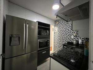 cocina con nevera de acero inoxidable y fregadero en Apartamento Excelente e Confortável no Flamengo, en Río de Janeiro