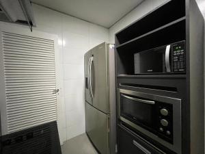 a kitchen with a microwave and a refrigerator at Apartamento Excelente e Confortável no Flamengo in Rio de Janeiro