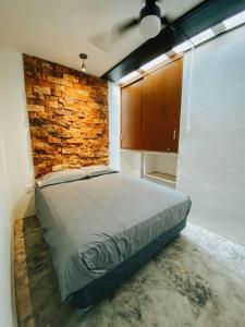 1 dormitorio con cama y pared de ladrillo en Brand new Modern Casa w/ Pool 7 mins from Centro, en Mérida