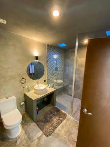 y baño con aseo, lavabo y espejo. en Brand new Modern Casa w/ Pool 7 mins from Centro, en Mérida