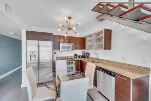 a kitchen with a glass table and stainless steel appliances at Iconic 1BR loft Brickell-Waterviews in Miami
