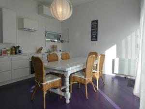 聖屈艾波爾特里厄的住宿－Maison avc Piscine, Spa Etables Mer proche plages，餐桌、椅子和厨房