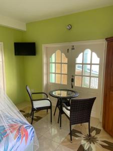 a room with a table and chairs and a bed at Greenhouse on the Hill, Sea View Studio Apartment in Laborie