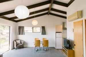 a kitchen and dining room with a table and chairs at Unit 7 Kaiteri Apartments and Holiday Homes in Kaiteriteri