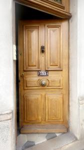una puerta de madera con un cartel en Appartement privé « Rive Droite », en Serrières