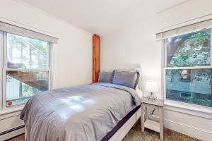 um quarto com uma cama e duas janelas em Vermont Marble Haven em Rutland