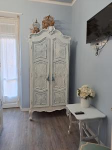 Marie Antoinette-Pala Alpitour- Private Parking في تورينو: خزانة بيضاء في غرفة مع طاولة