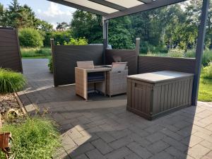 patio ze stołem i krzesłami w obiekcie Gemütliche FeWo mit Badeseeblick - Klimafreundlich w mieście Uplengen