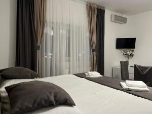 um quarto de hotel com uma cama grande e uma janela em Rooms Elez em Sesvete