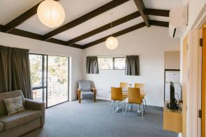 uma sala de estar com um sofá, uma mesa e cadeiras em Unit 7 Kaiteri Apartments and Holiday Homes em Kaiteriteri