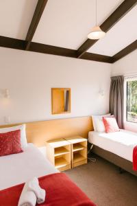 a hotel room with two beds and a window at Unit 7 Kaiteri Apartments and Holiday Homes in Kaiteriteri