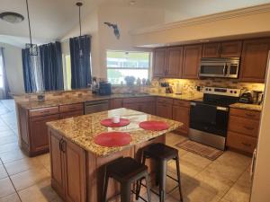 a kitchen with a island with red plates on it at Casa in The Cove in Cape Coral