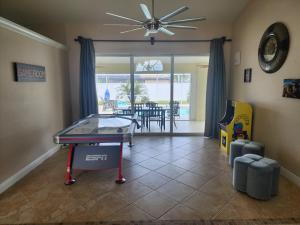 Habitación con mesa de ping pong y comedor. en Casa in The Cove en Cape Coral